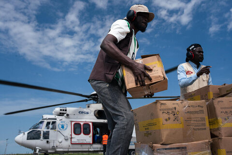 Men unload boxes from a helicopter
